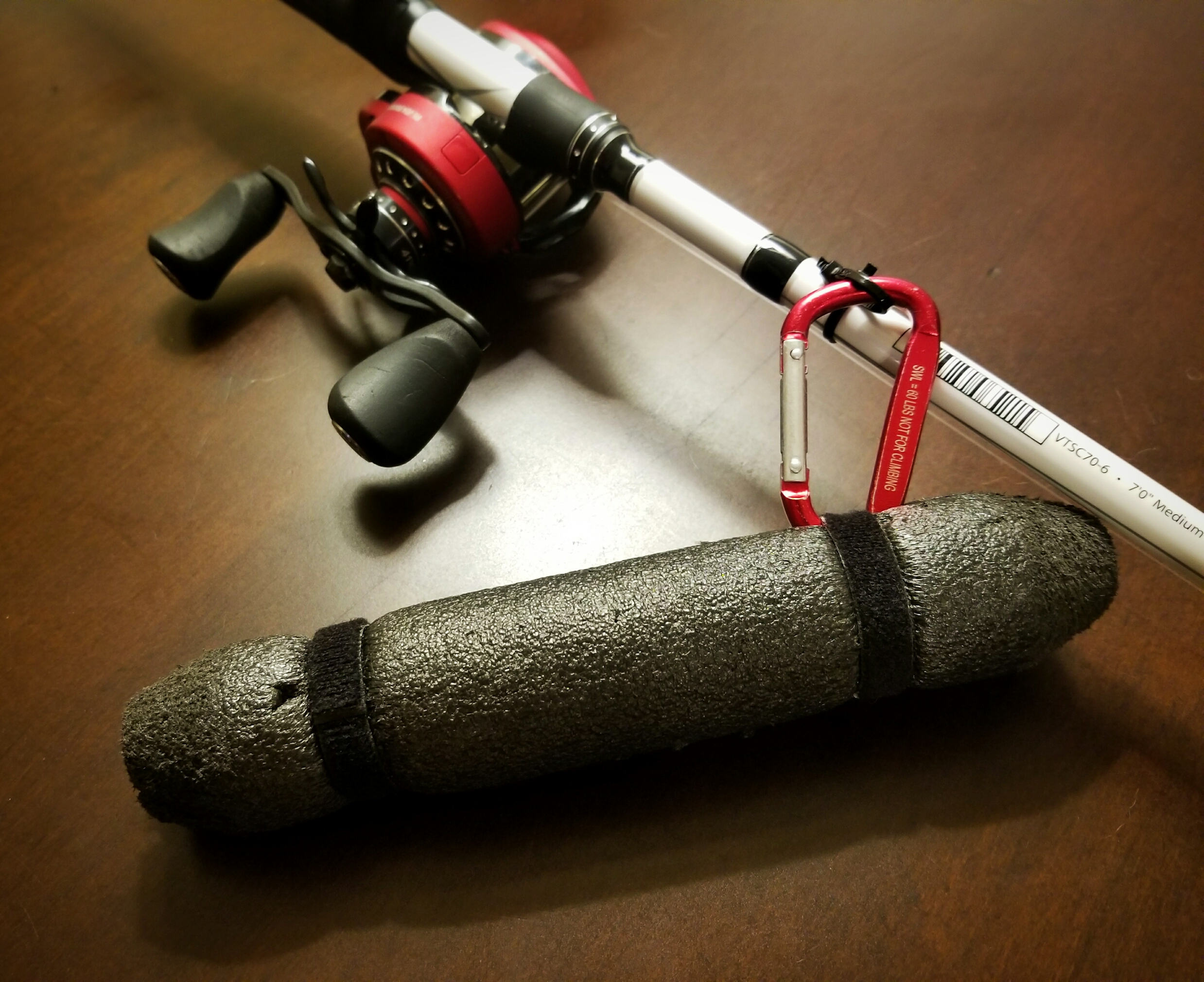 Abu Garcia rod and reel with a black rod float clipped to the zip-tie on the blank