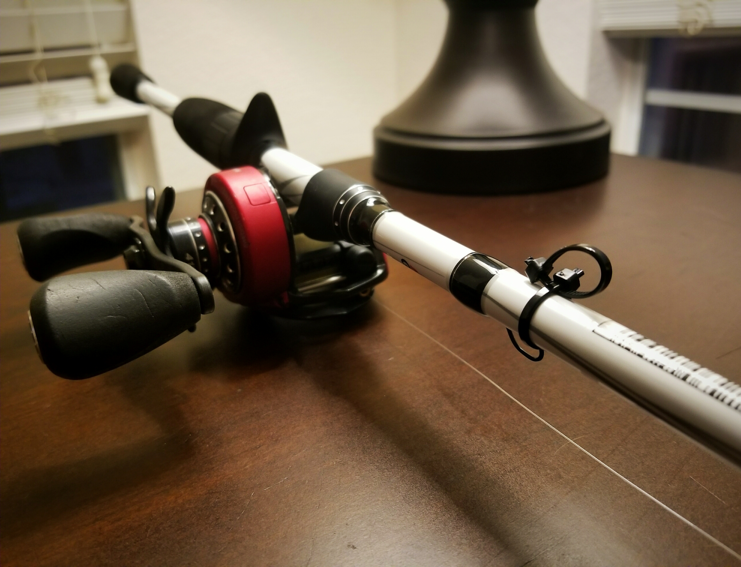 Abu Garcia rod and reel with two black zip-ties attached low on the blank