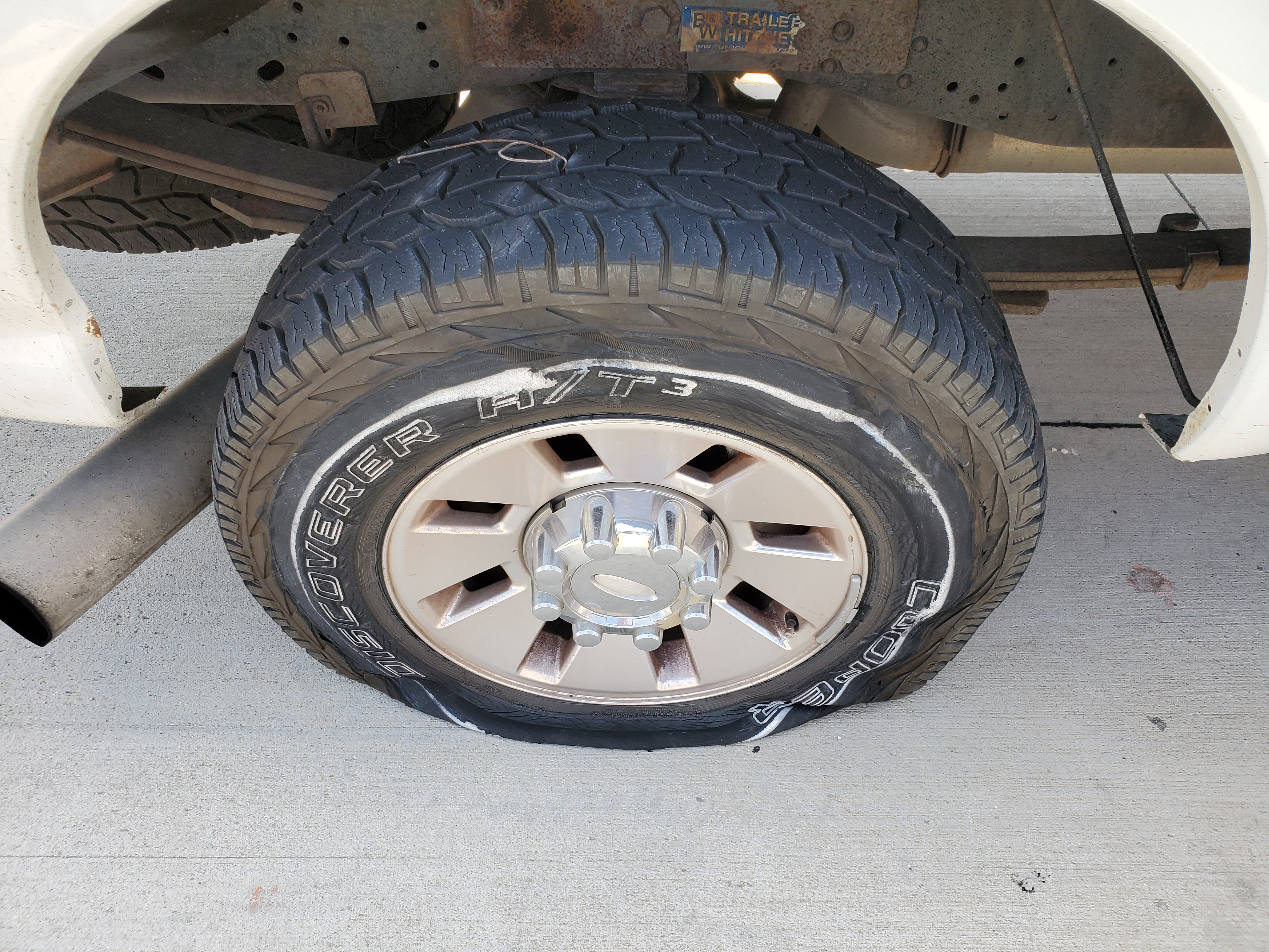A flat tire on our F-250 pickup truck with a wire sticking out of the tire