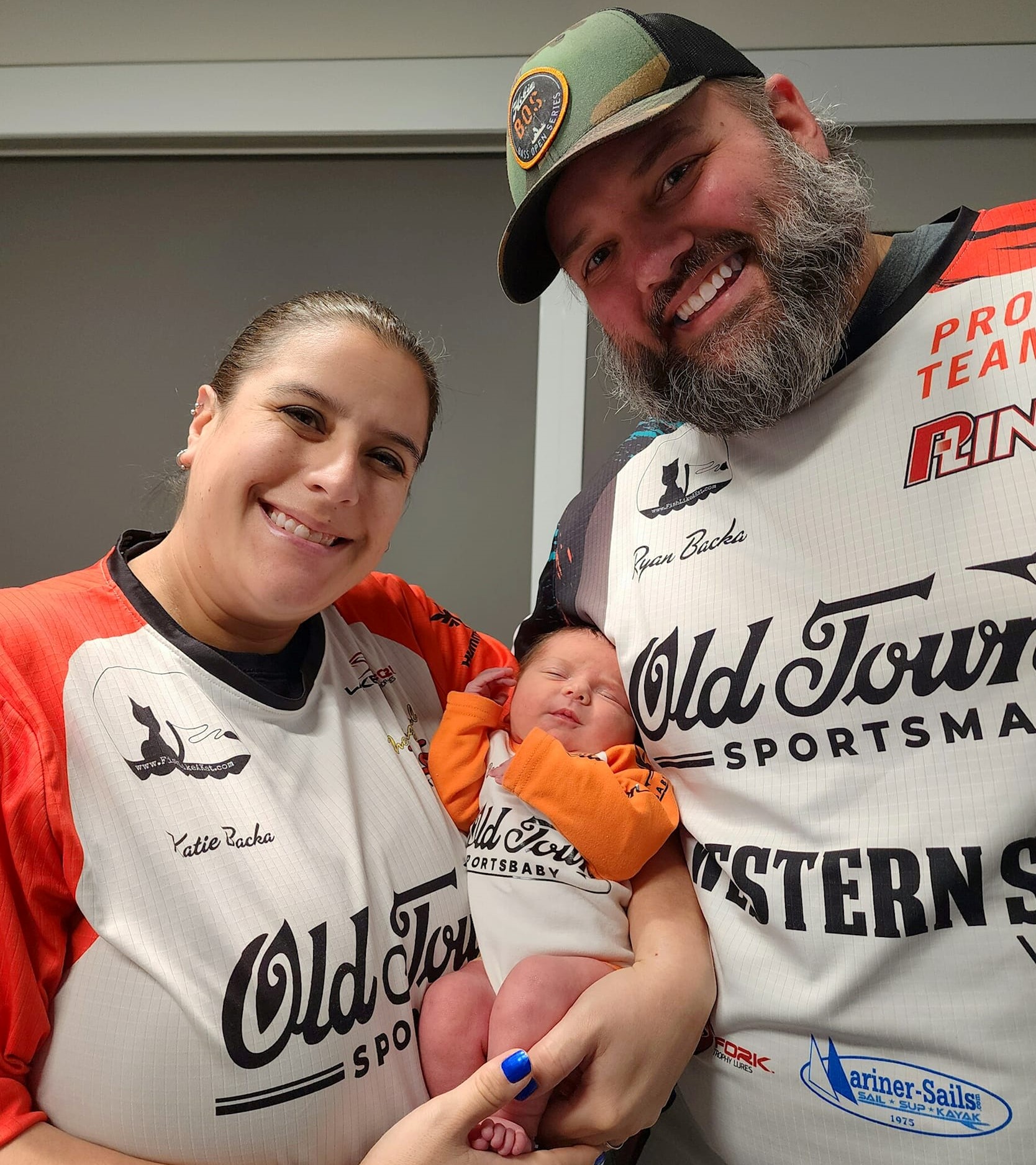 Text: Katie and Ryan holding Lily in their jerseys