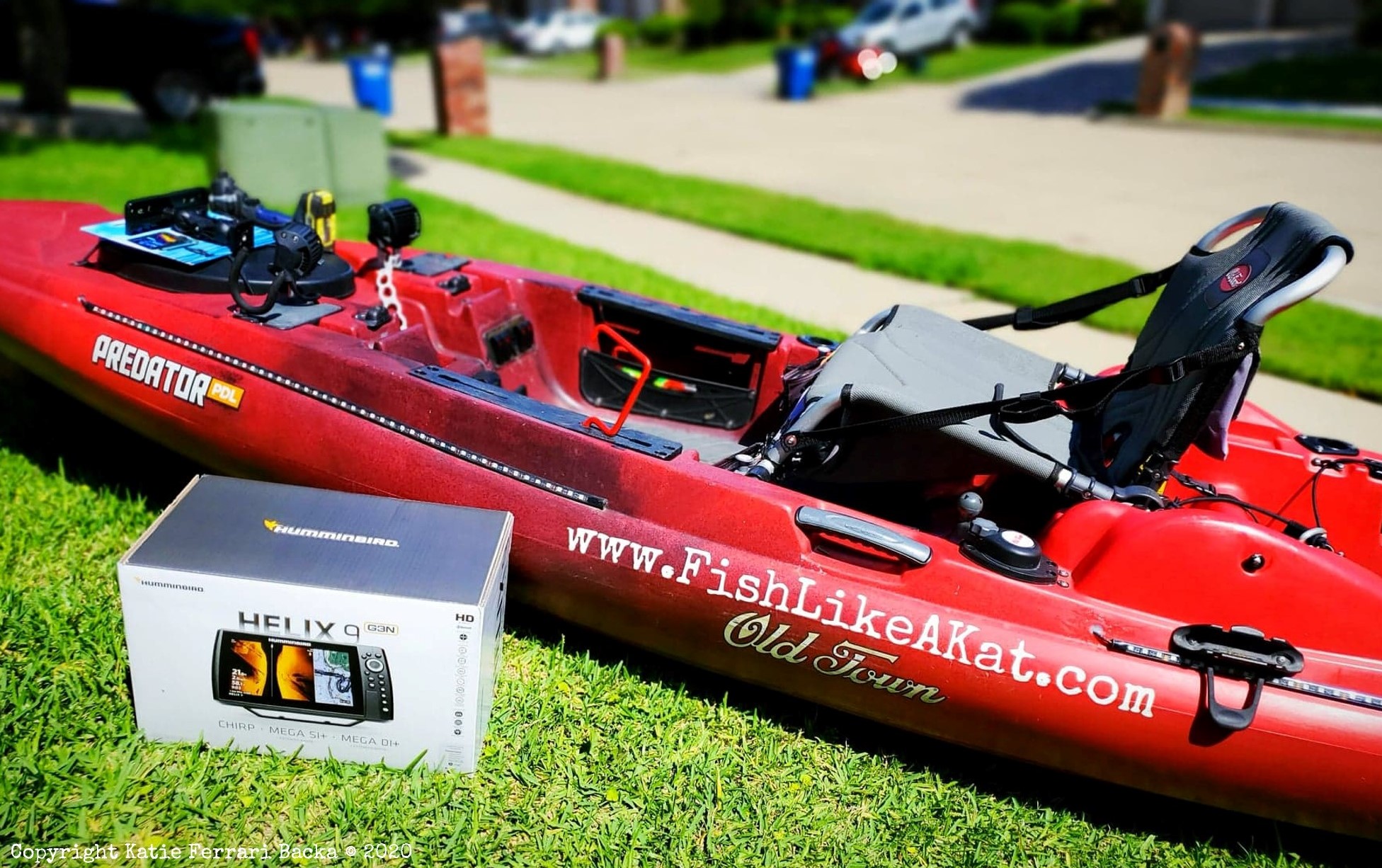 A red Old Town Predator PDL kayak with a Humminbird Helix 9 fish finder in front of it