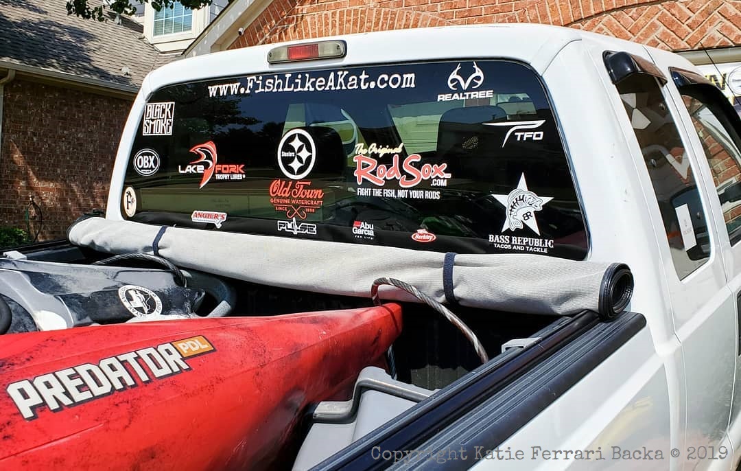 The back window of the truck with sponsor decals all over it