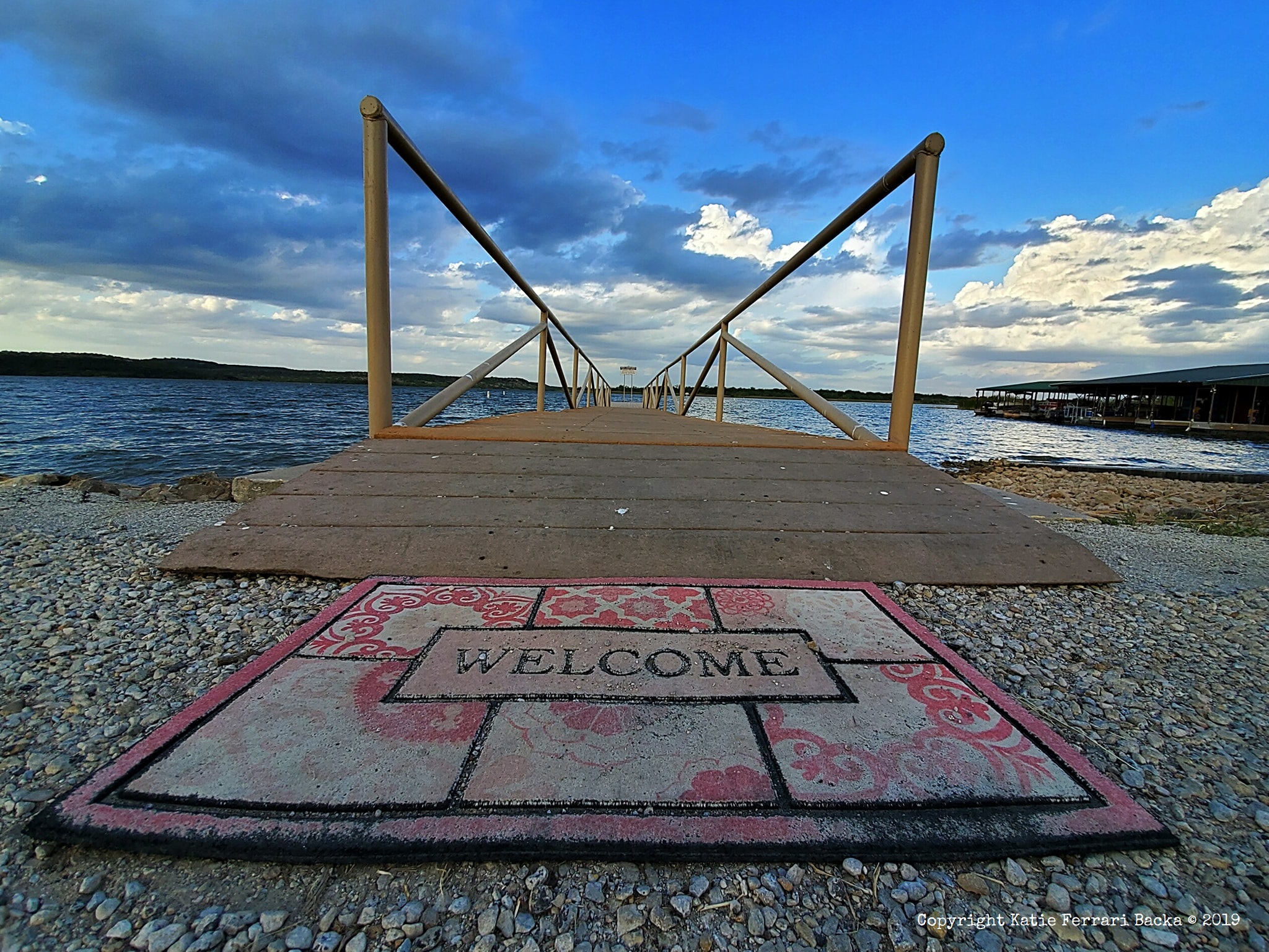 Landscape shot at the end of a dock with a welcome mat at Possum Kingdom Lake