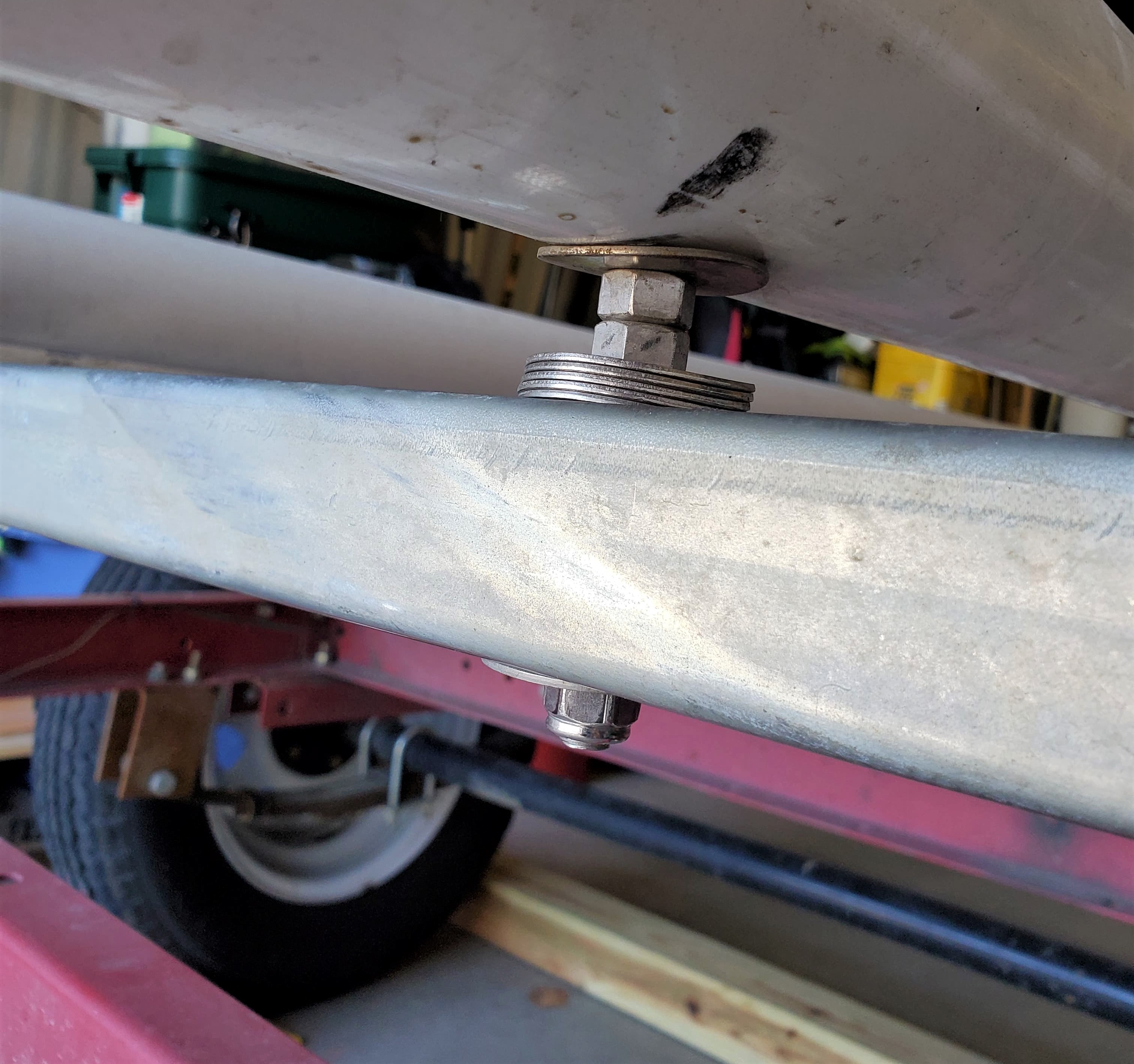 View of the underside of a PVC pipe attached to a strut on a trailer
